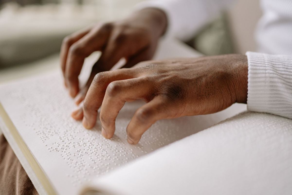 Close-up of fingertips reading braille